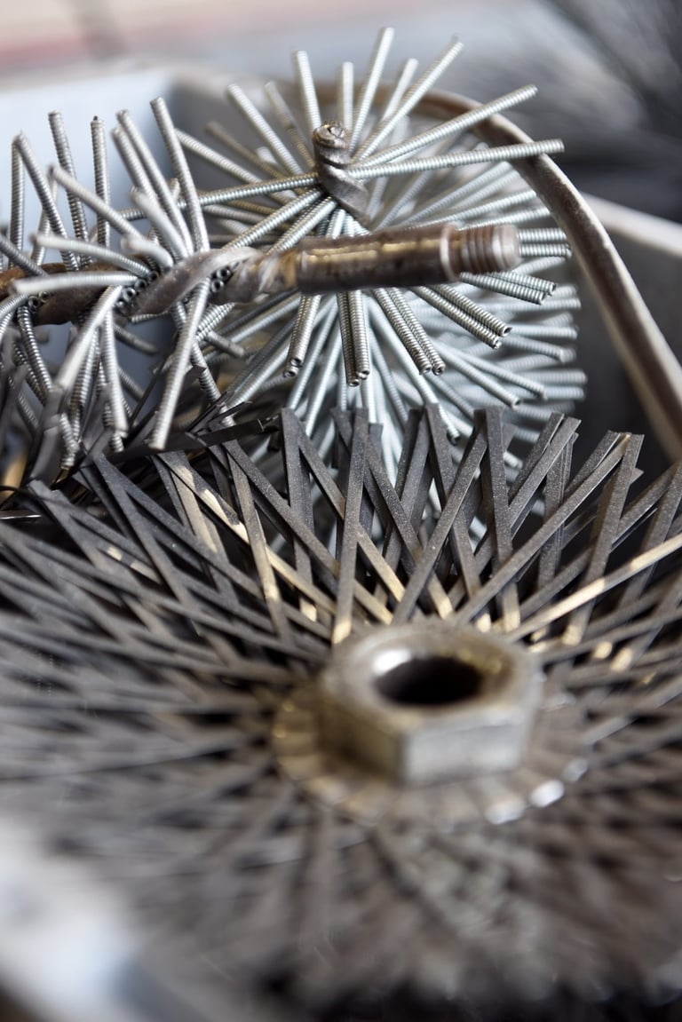 Nahaufnahme einer zylindrischen Bürste mit Drahtborsten und Metallstab in der Mitte